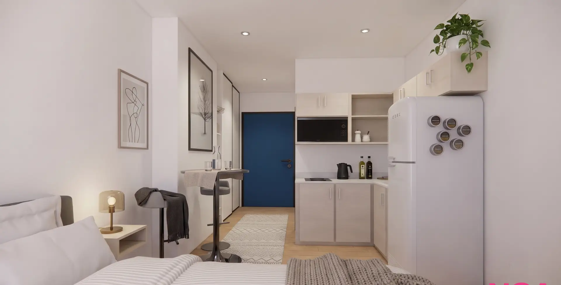 A renovated studio suite at The Horton — bed, kitchenette, and navy entry door